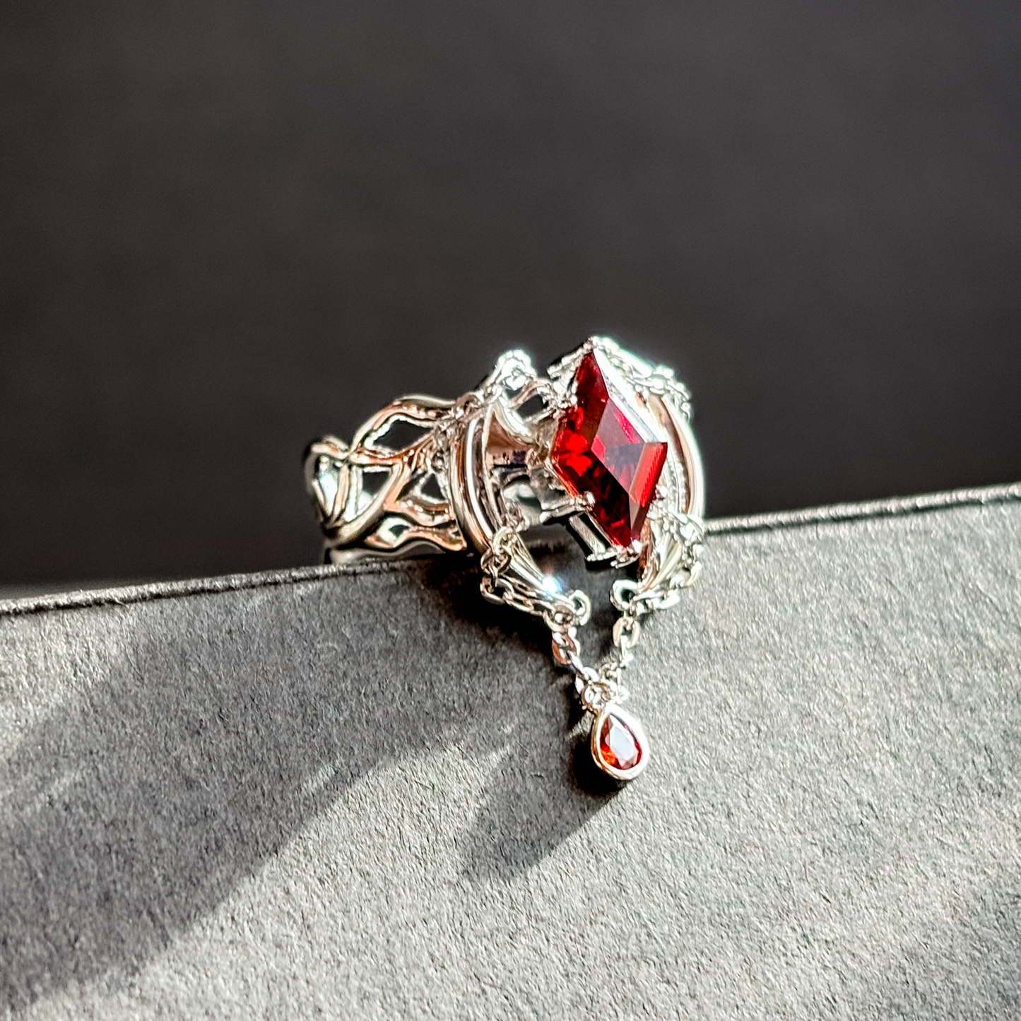 Decorative brooch with red gemstone on a textured surface RAILWAY BANGCHAN Stray kids Kpop merch